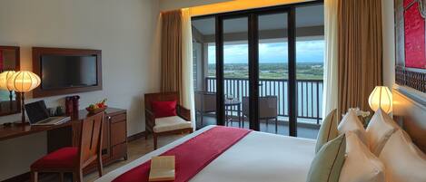 Une chambre d’hôtel équipée d’un lit, d’un bureau, d’un ordinateur portable, d’une chaise et d’un balcon avec vue.
