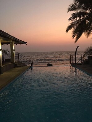 Een buitenzwembad en een infinitypool