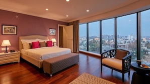 Una habitación de hotel moderna con una cama grande, una silla y vistas a la ciudad.