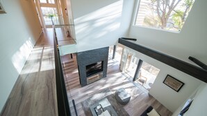 A spacious living area with a fireplace, a balcony, and large windows allowing natural light. - La Cachette (Hakodate)