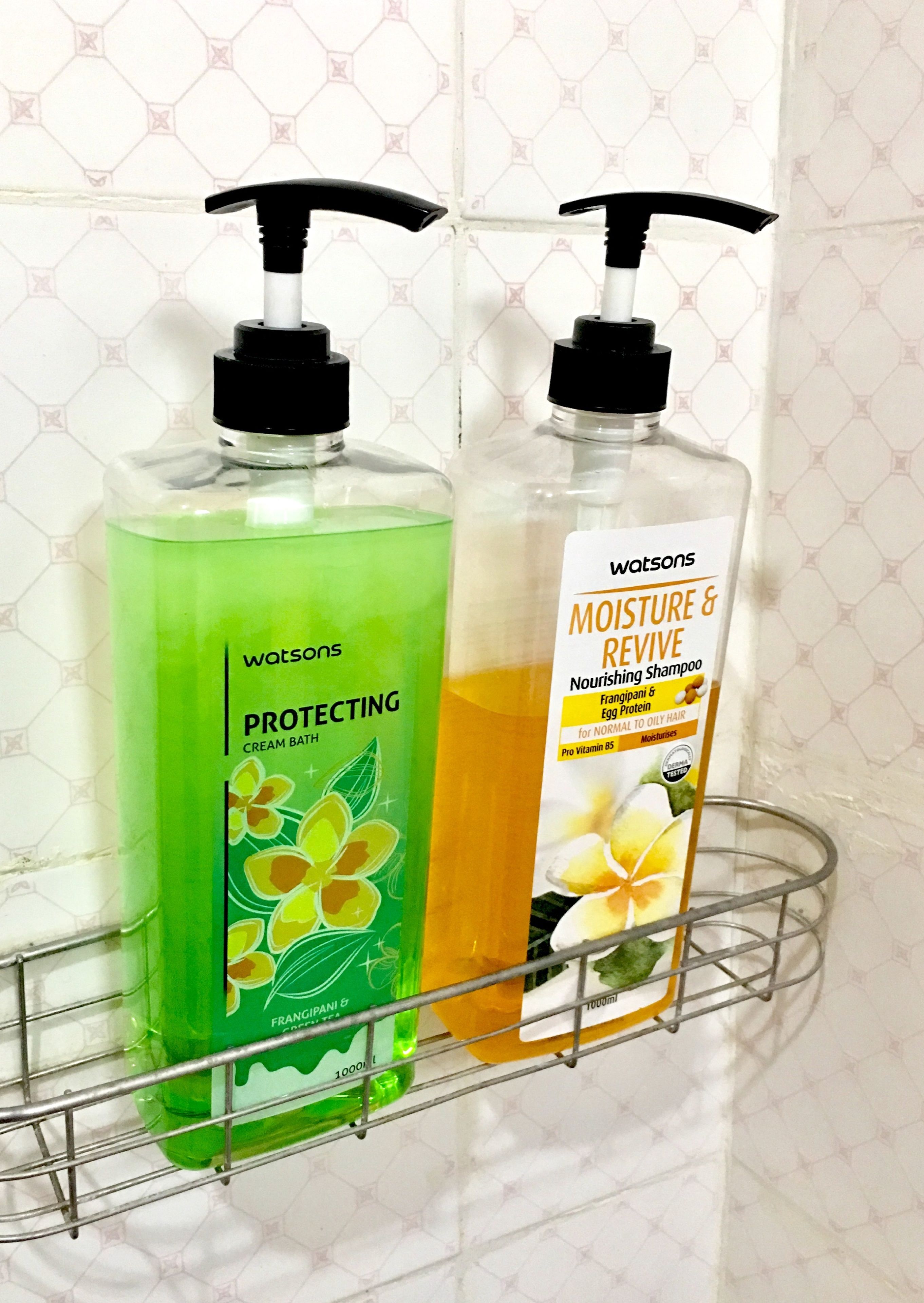 Zwei Flaschen Watsons Shampoo auf einem Metallregal.