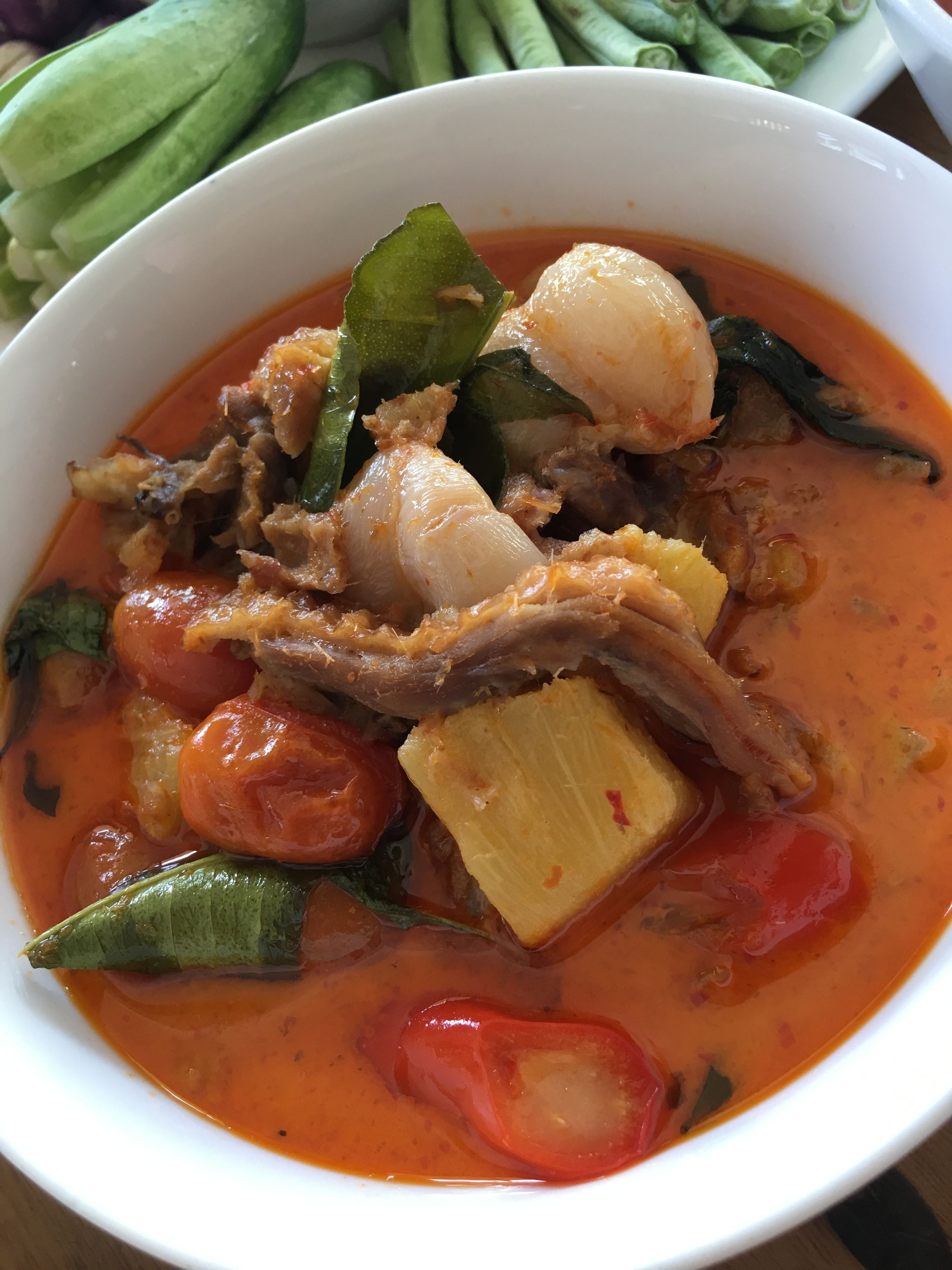 A bowl of soup with various vegetables and meat.