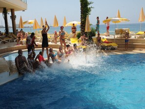 Una piscina cubierta, una piscina al aire libre, sombrillas, tumbonas