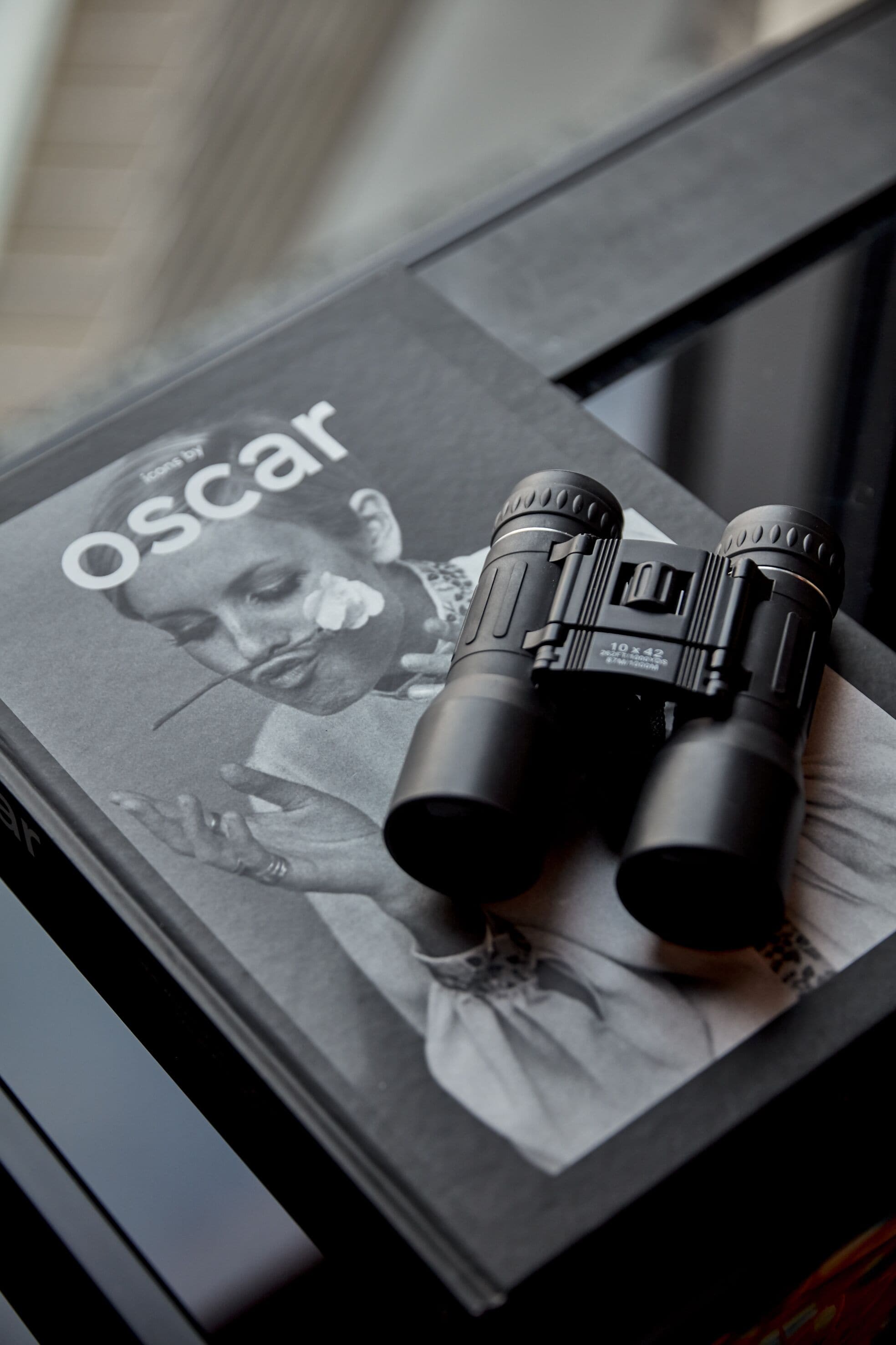 Une paire de jumelles est visible sur la couverture d’un magazine, et le mot « Oscar » y est également visible.