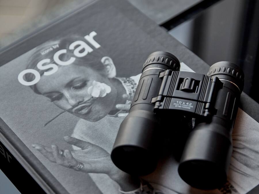 Une paire de jumelles est visible sur la couverture d’un magazine, et le mot « Oscar » y est également visible.
