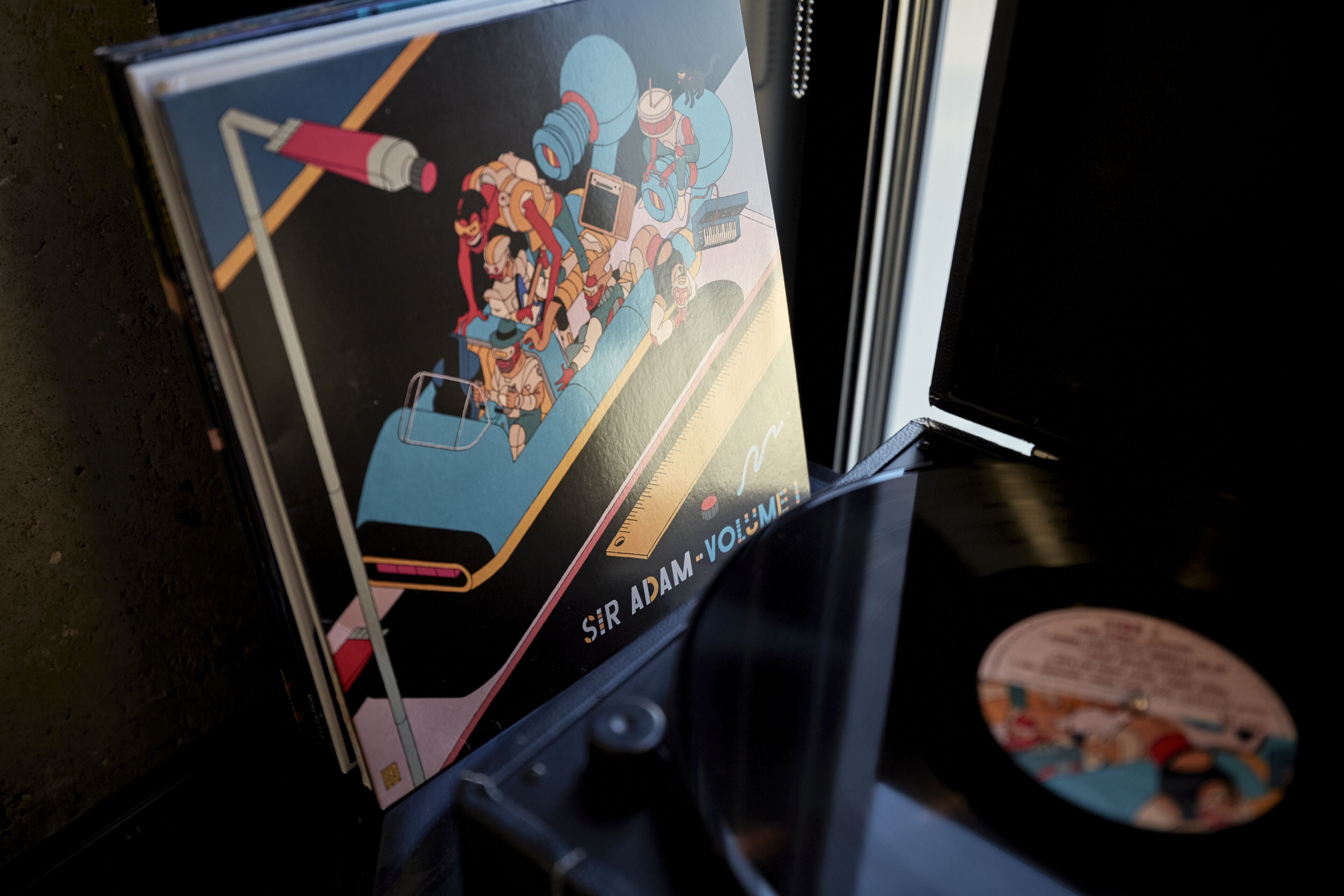 Un disque vinyle et un livre à la couverture colorée.