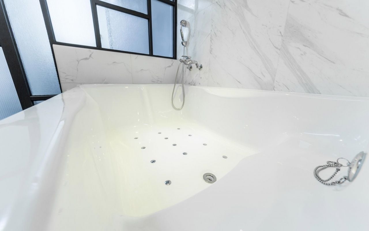 Une salle de bain moderne avec une grande baignoire, une douche et un mur en marbre.