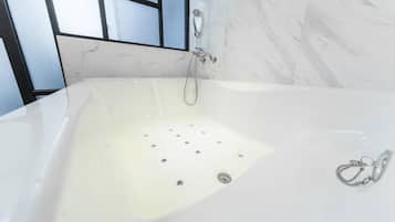Une salle de bain moderne avec une grande baignoire, une douche et un mur en marbre.