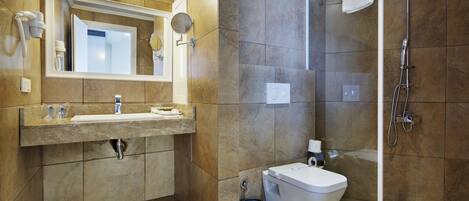 A modern bathroom with a large mirror, a sink, a toilet, and a shower.