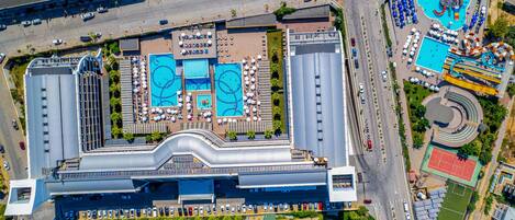 Un gran hotel con varias piscinas, cancha de tenis y parque acuático.