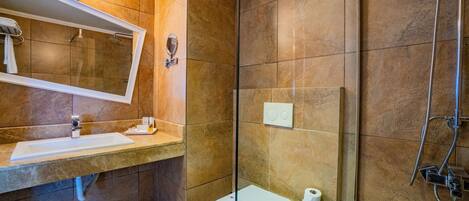 Un baño con lavamanos, espejo, inodoro y ducha.