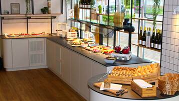 Ein Bereich mit einem Buffet, verschiedenen Speisen und Weinflaschen.