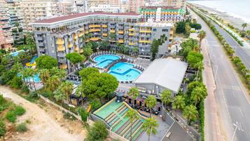 Un hotel de gran altura con varios balcones, piscina y bar en la azotea.