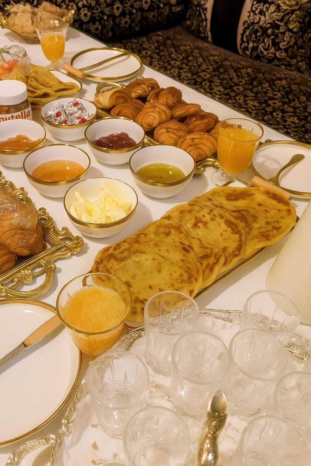 A table set with various breakfast items including pastries, bread, and condiments.