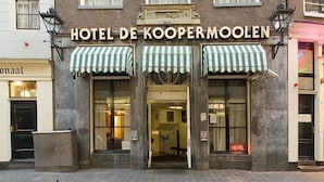Hotel De Koopermolen with a traditional facade, two green-striped awnings, and a visible entrance. - Hotel De Koopermoolen (Amsterdam)