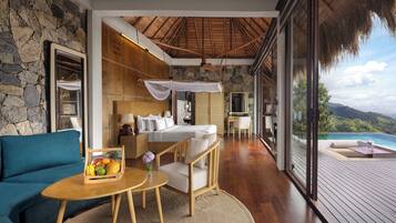 Relax in a serene room with a large bed, ocean views, and a seating area.