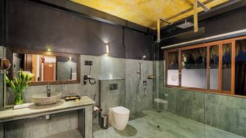 Une salle de bain moderne avec un grand miroir, un lavabo en pierre, des toilettes et un espace douche.