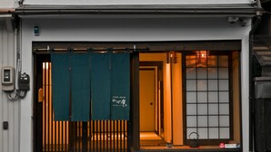 A traditional Japanese building with a two-story entrance, sliding doors, and a small window with a view. - Hashibaan (Kanazawa)