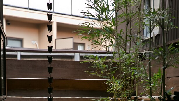 A wooden deck with a bamboo plant and a decorative light fixture. - Hashibaan (Kanazawa)
