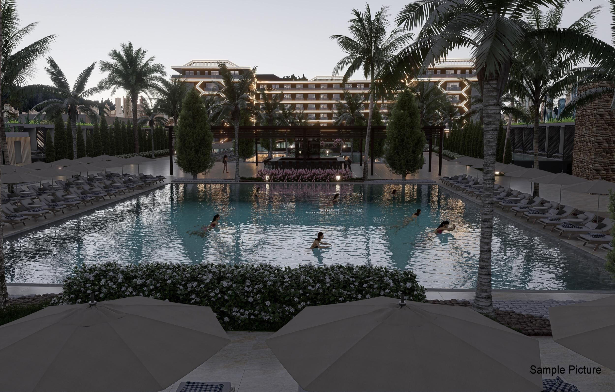 Ein Hotelpoolbereich mit mehreren Schwimmbecken, Liegestühlen, Palmen und einem großen Gebäude im Hintergrund.
