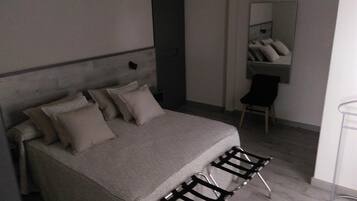 Un dormitorio pequeño y moderno con cama, una silla y un escritorio.