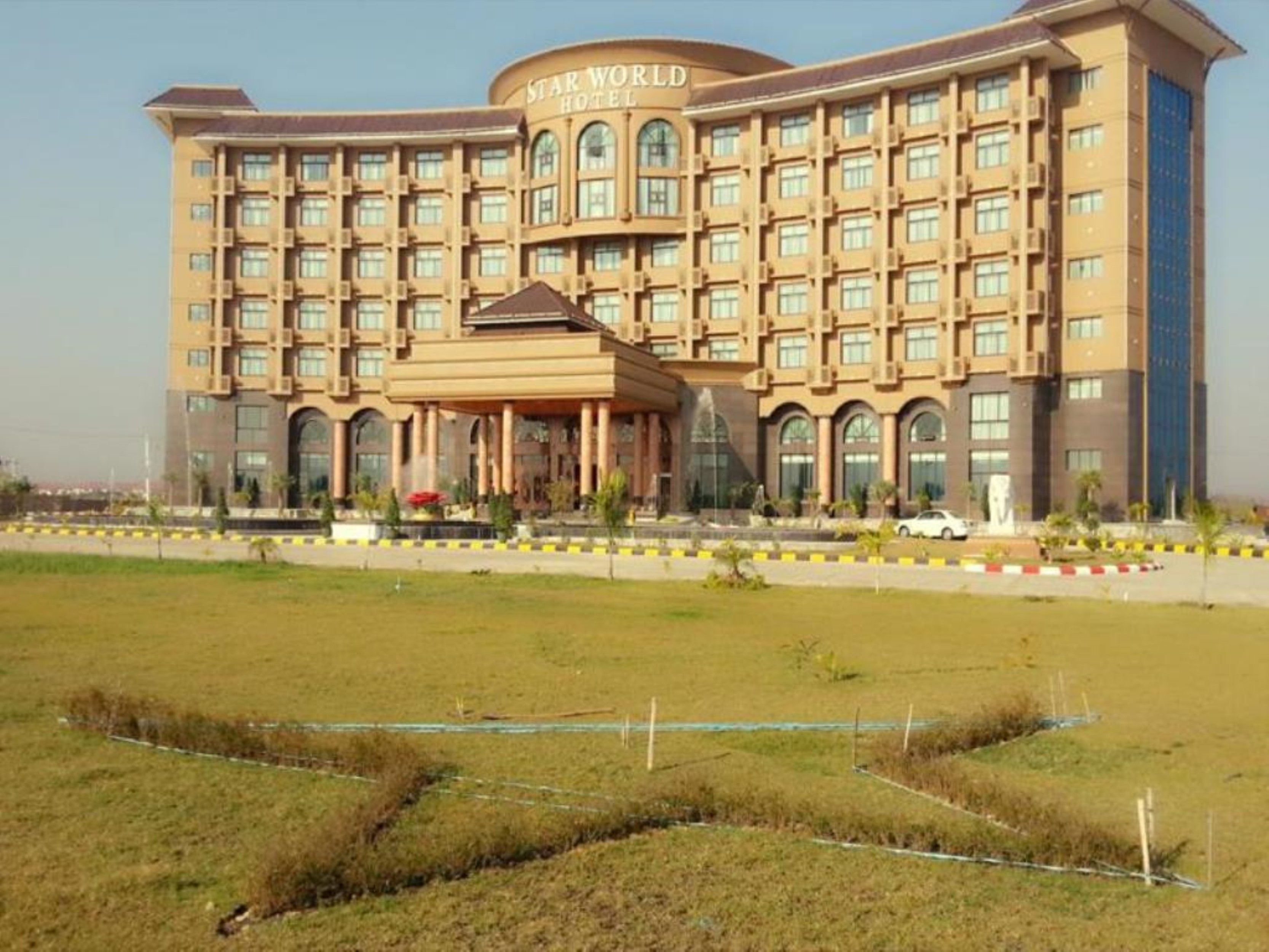 A large hotel with a central entrance and multiple floors.
