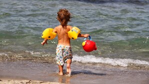 Ein Kind spielt mit Strandspielzeug am Strand.