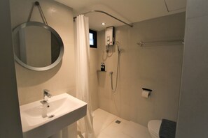 Une salle de bain moderne équipée d’un lavabo, d’une douche et de toilettes.