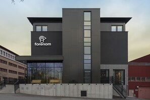 Un edificio moderno con un logotipo destacado y una escalera que conduce a la entrada.