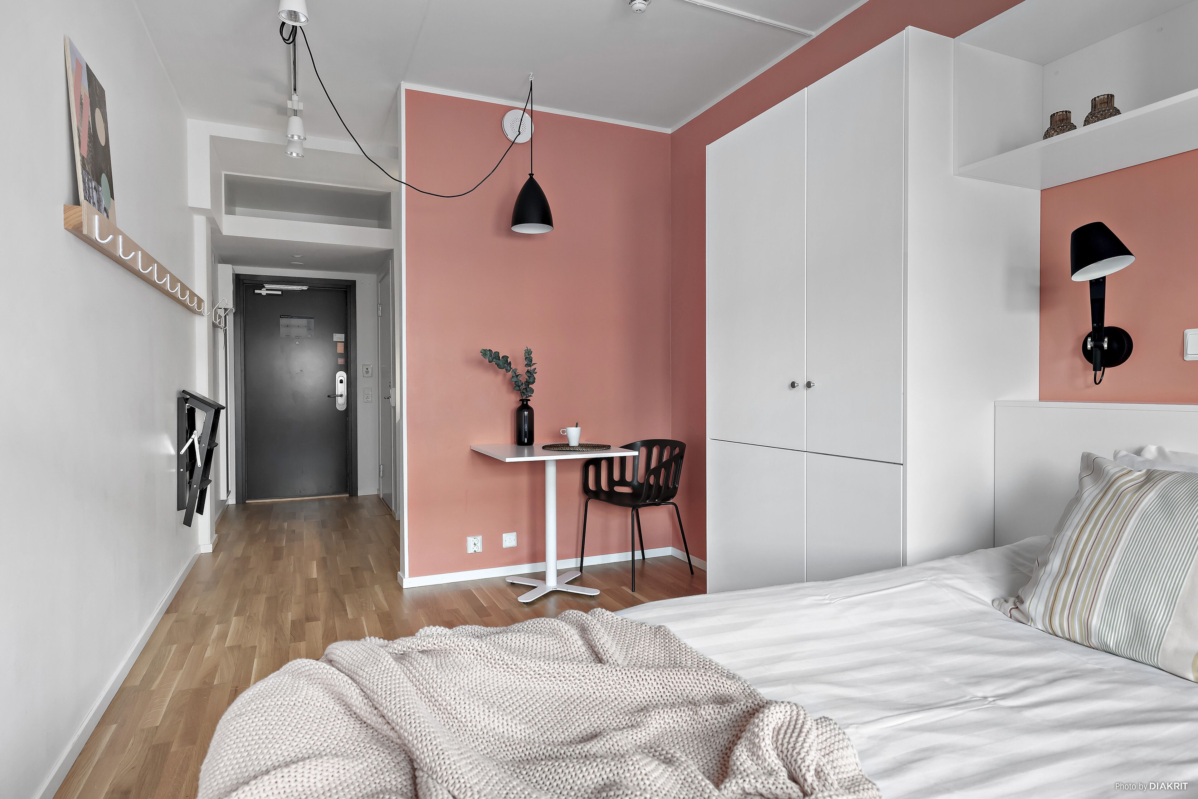 A bedroom with a bed, a desk, and a chair.