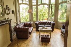 A room with a large window, a fireplace, and a leather sofa set. - Apart - Hotel Saint Georges (Mons)