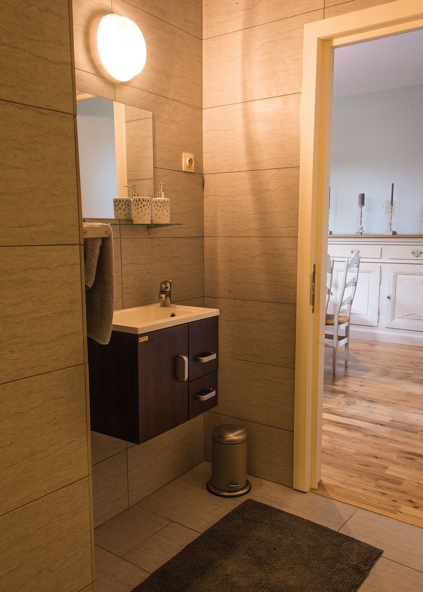 Een moderne badkamer met een wastafel, spiegel en handdoekhouder.
