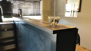 Una cocina moderna con encimera de madera, horno empotrado y ventana con persianas.