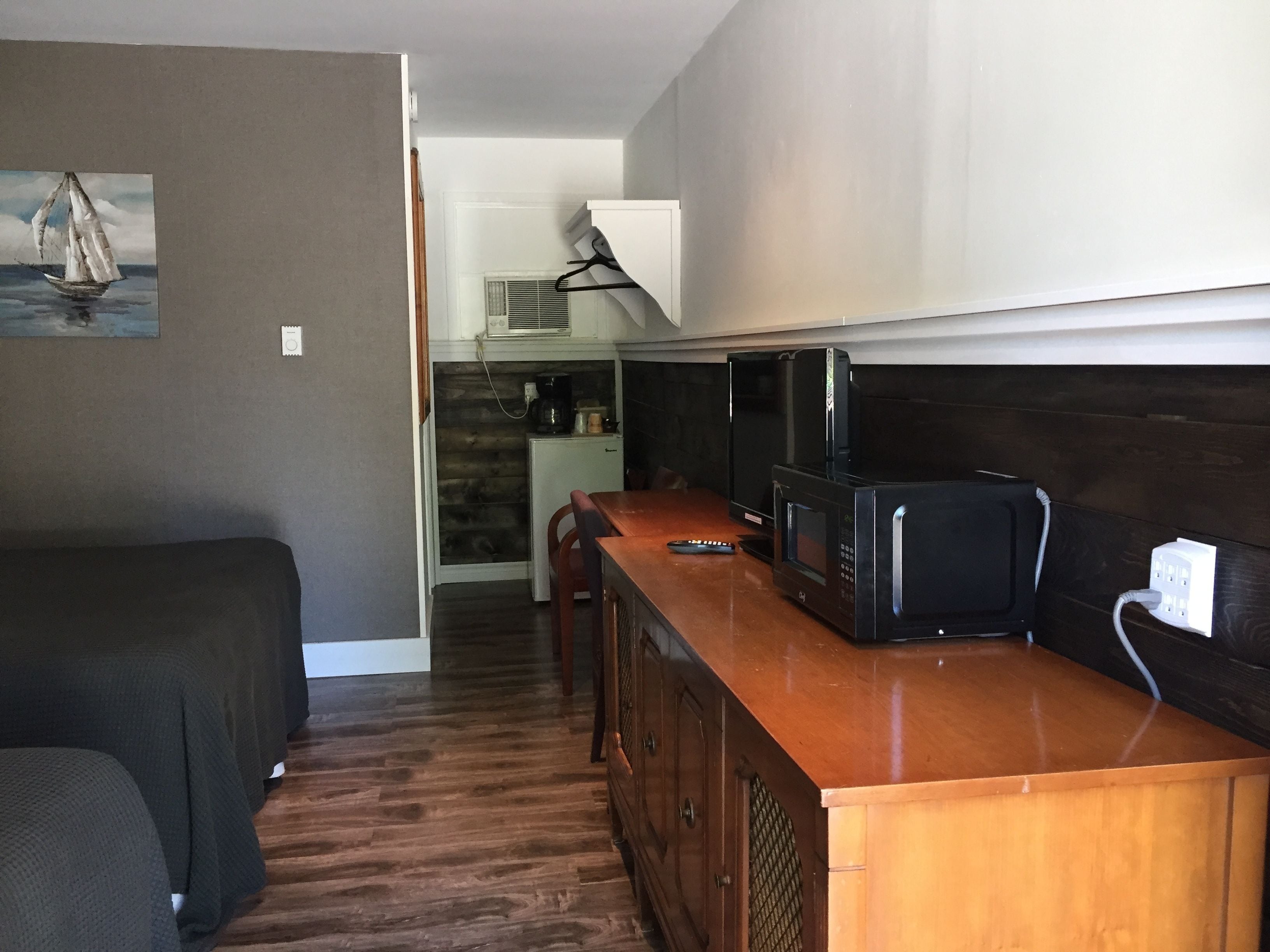 A compact kitchen with a wooden countertop, a microwave, and a coffee maker.