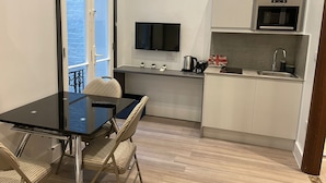 Una cocina compacta con comedor, televisor de pantalla plana y microondas.