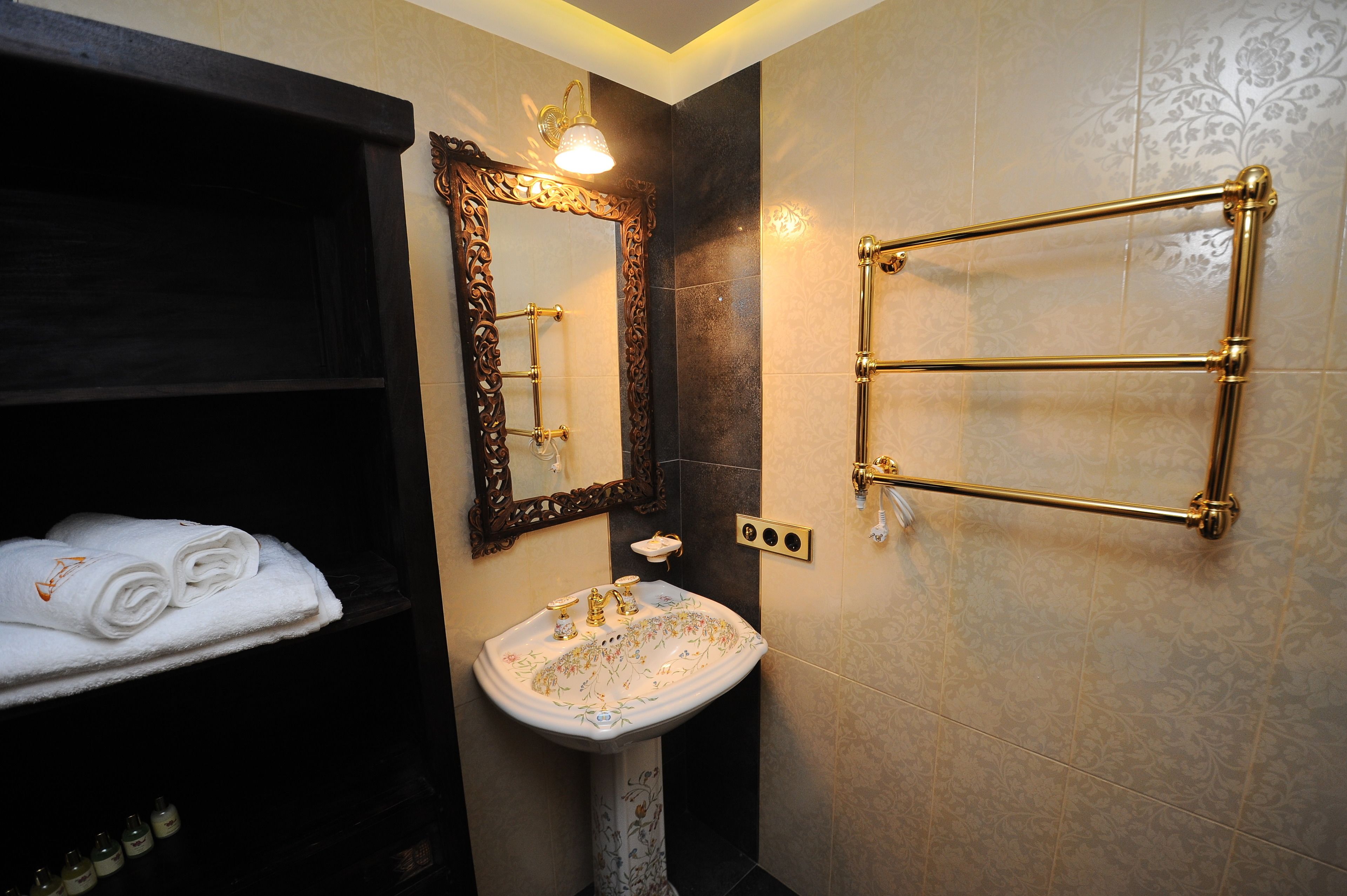 A bathroom with a white sink, a mirror, and a towel rack.