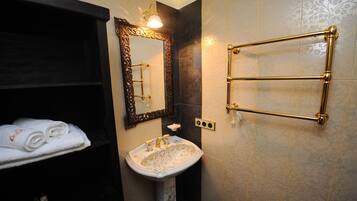 A bathroom with a white sink, a mirror, and a towel rack.