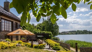 A lakeside patio with outdoor seating, a wooden pergola, and a view of the lake. - Argo Trakai (Trakai)