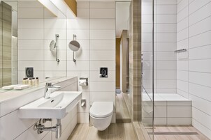 Un baño moderno con lavamanos, inodoro y zona de ducha.