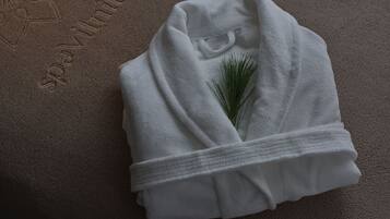 A white towel with a pine branch, placed on a textured surface with embossed text.