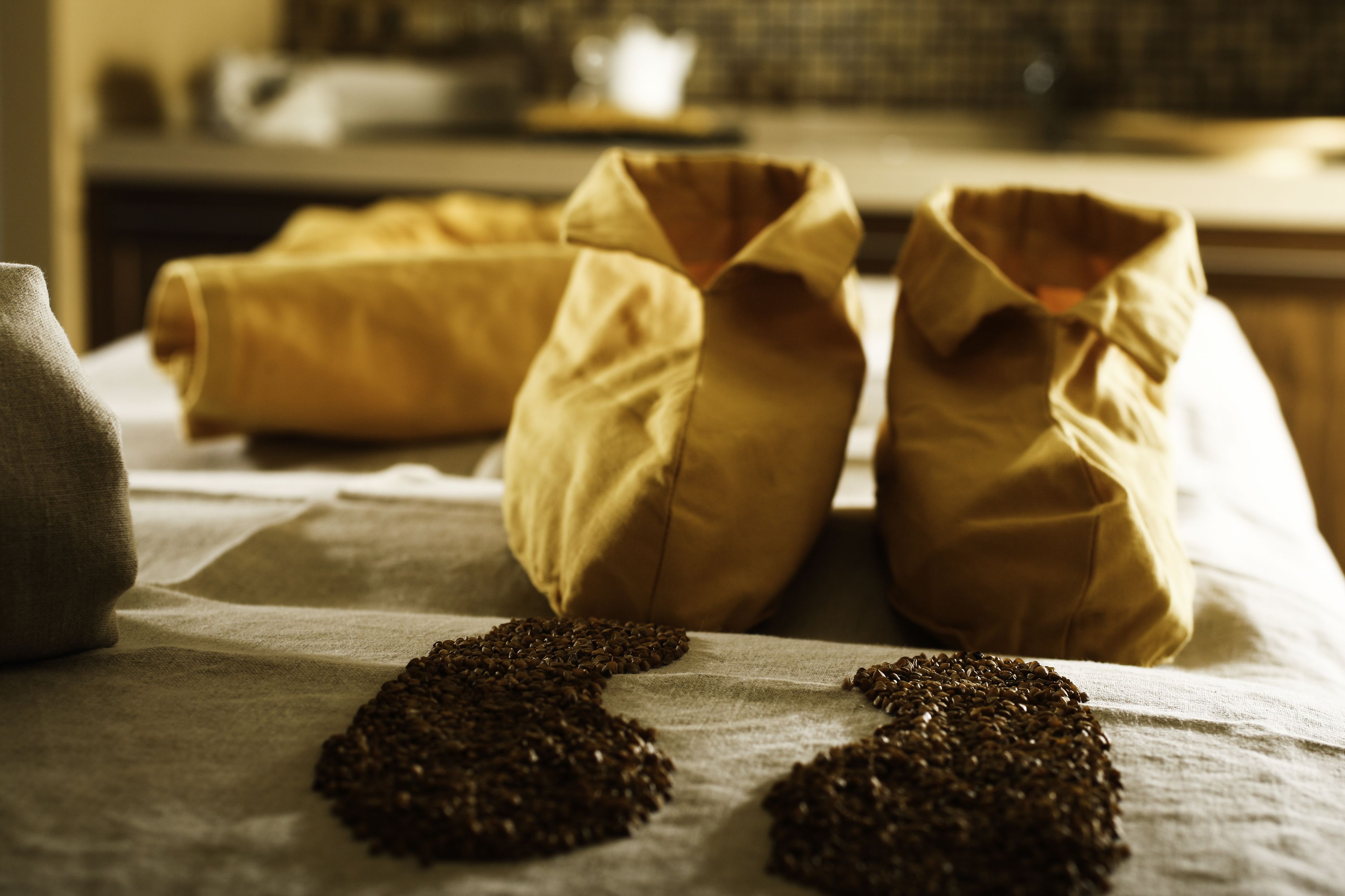 Two sacks of coffee beans on a table with a cloth.