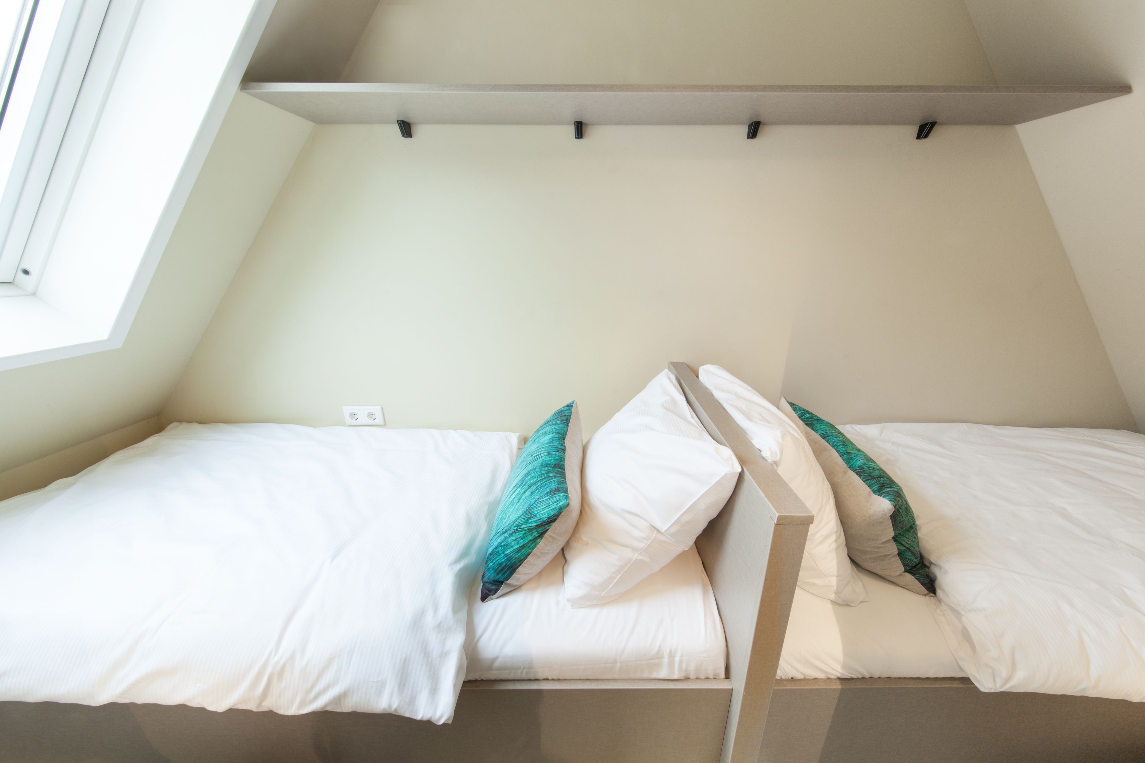 Ein kleiner, gemütlicher Raum mit einem Etagenbett und einem Fenster.