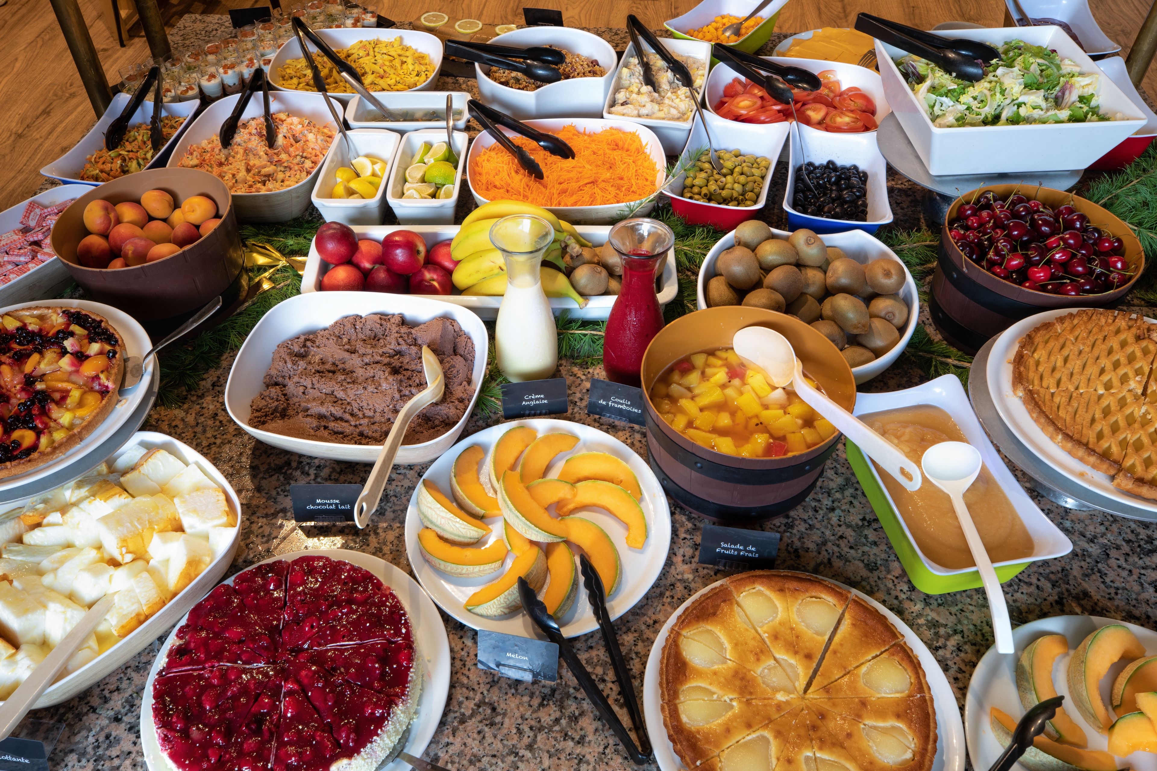 A buffet with various food items and utensils.