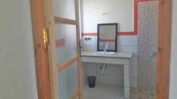 A bathroom with a white sink, mirror, and tiled walls.