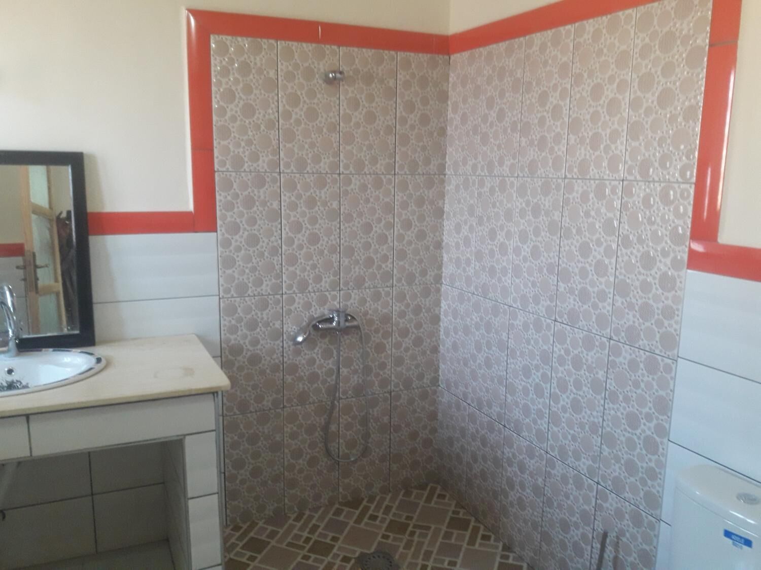 Ein Badezimmer mit Dusche, Waschbecken und Spiegel.