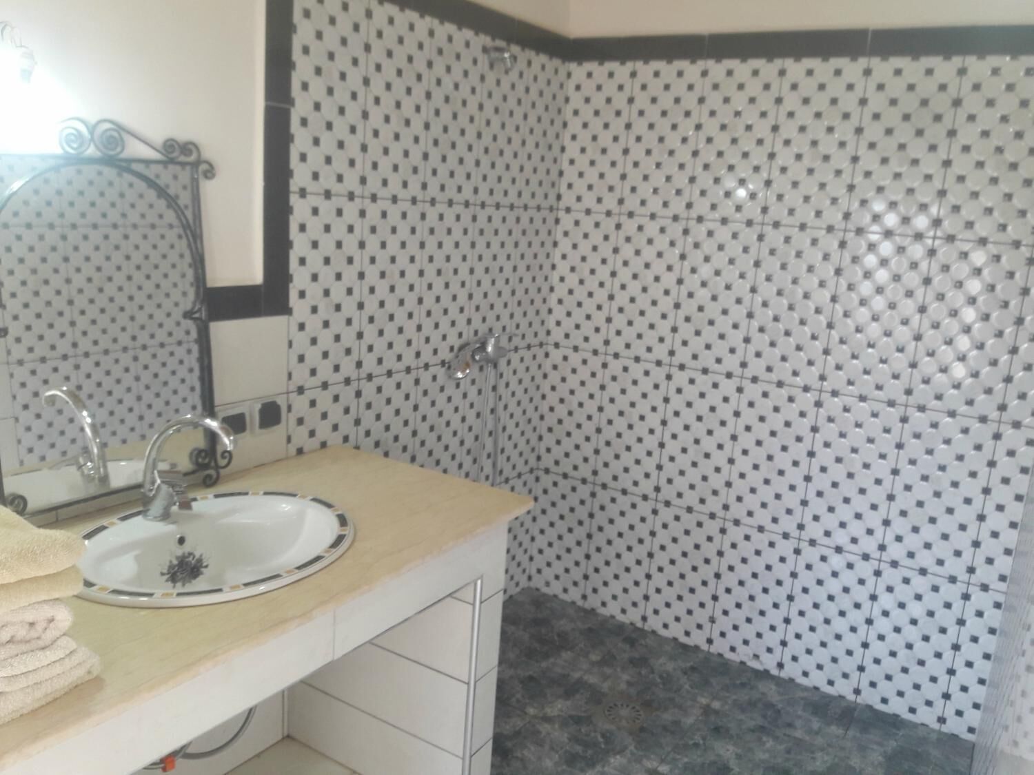 A bathroom with a sink, mirror, and tiled walls.