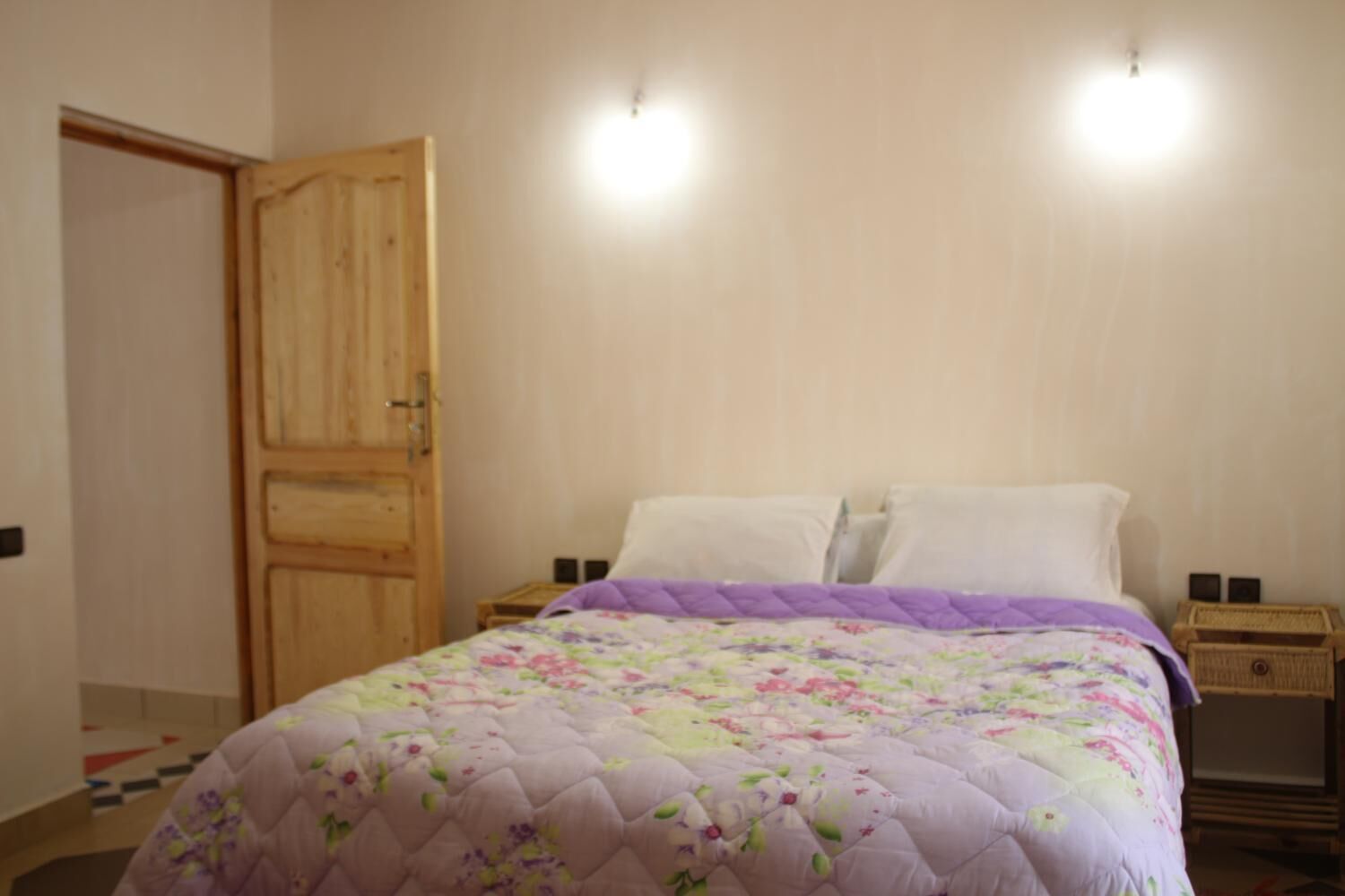 Un dormitorio con una cama, un armario de madera y dos mesitas de noche.