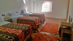 Una habitación con dos camas, una ventana y una silla.