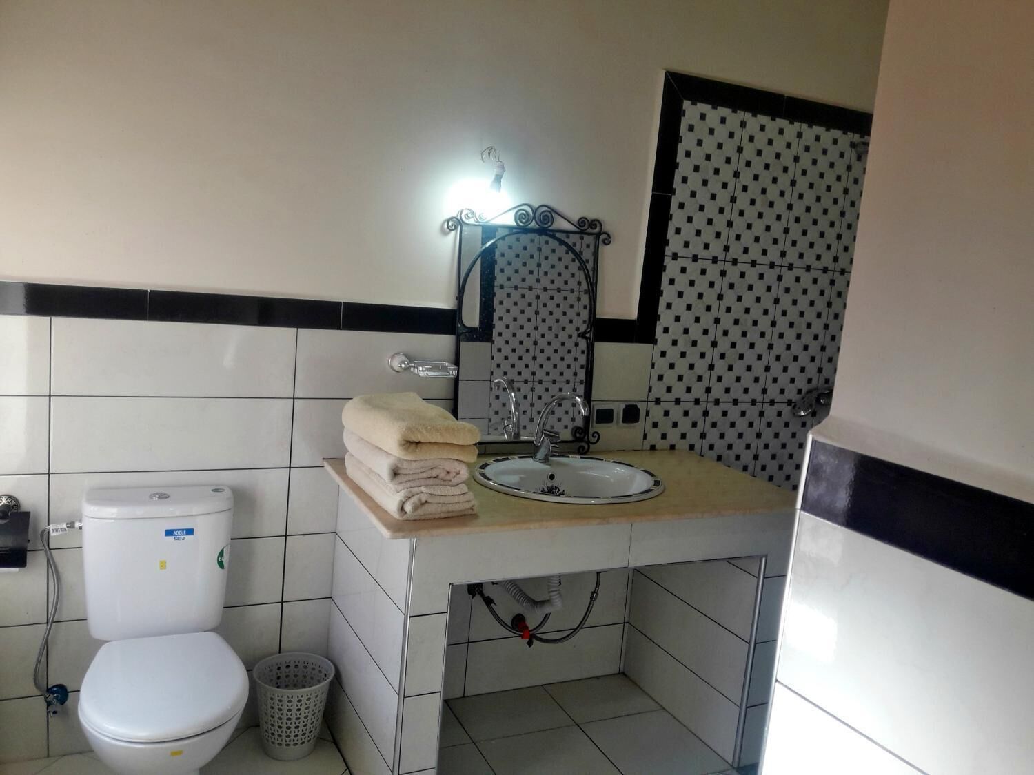 Une salle de bain avec des toilettes, un lavabo et une pile de serviettes.