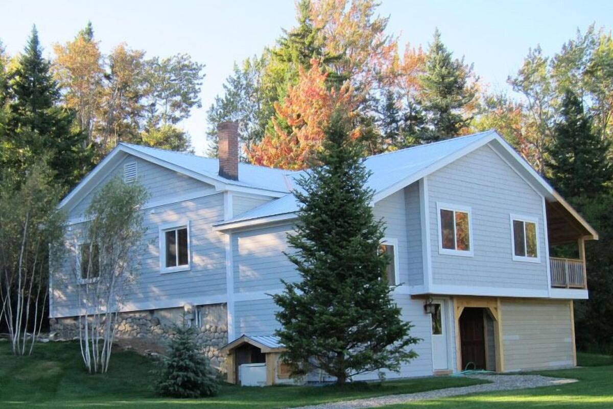 A two-story house with a stone foundation, a chimney, and a garage.